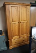 A pine double door wardrobe fitted a drawer CONDITION REPORT: Height 192.5 cm.