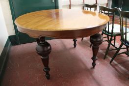 A circular antique mahogany dining table on bulbous legs