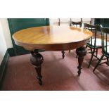 A circular antique mahogany dining table on bulbous legs