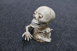 A cast iron novelty skeleton money box