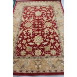 A floral woolen rug on red ground