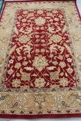 A floral woolen rug on red ground