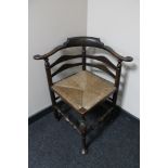 An antique oak rush seated corner chair