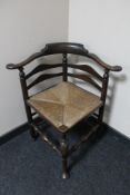 An antique oak rush seated corner chair