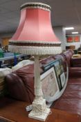 A cream carved table lamp with tassel shade