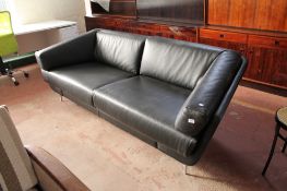 A shaped black leather two seater settee on metal legs