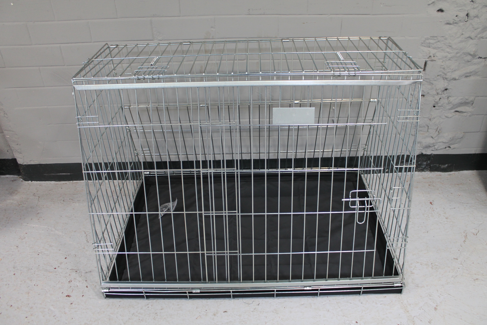 A folding metal dog cage width 97 cm