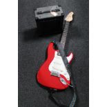 An Encore electric guitar with carry strap together with a KLA 10 lead amplifier