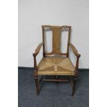 An Edwardian mahogany rush seated armchair