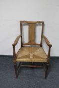 An Edwardian mahogany rush seated armchair