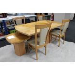 A contemporary pine effect high gloss pedestal dining table and four high backed chairs and