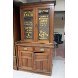 An Edwardian mahogany glazed door bookcase fitted with cupboards and drawers bearing haberdashery