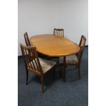A teak G Plan drop leaf table and four rail back chairs