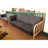 A blond oak framed three seater settee in charcoal fabric CONDITION REPORT: 208cm