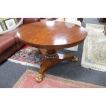 A Victorian circular breakfast table on three way pedestal with gilt lion paw feet