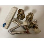 A box of silver pieces, pair of candlesticks, silver handled cheese knife in box,