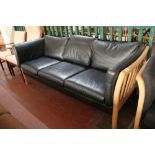 A contemporary wooden framed three seater settee in black leather CONDITION REPORT: