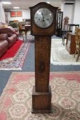 An oak cased granddaughter clock with pendulum and key