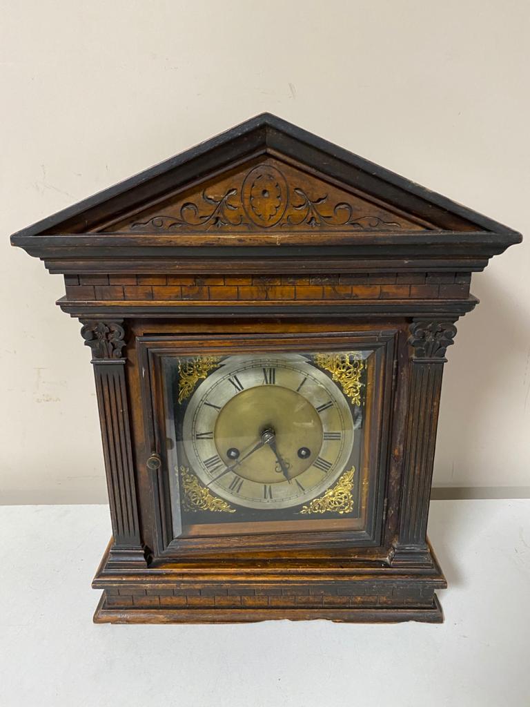 An antique pine cased bracket clock with brass and silvered dial with pendulum