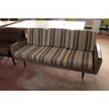 A mid century Danish teak armed three seater settee in a striped fabric CONDITION