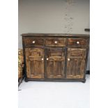 A stained pine triple door sideboard fitted with three drawers CONDITION REPORT:
