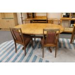 A mid 20th century oval teak G Plan extending table with shaped under stretcher,