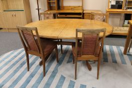 A mid 20th century oval teak G Plan extending table with shaped under stretcher,