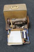 A cased Singer sewing machine together with a box of sewing accessories