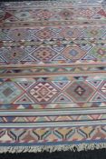 A fringed Kilim carpet on blue ground 301 cm x 246 cm.