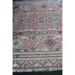 A fringed Kilim carpet on blue ground 301 cm x 246 cm.