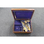 An Edwardian oak cutlery canteen containing cutlery,