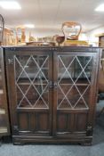 An oak double door bookcase with leaded glass doors