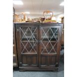 An oak double door bookcase with leaded glass doors