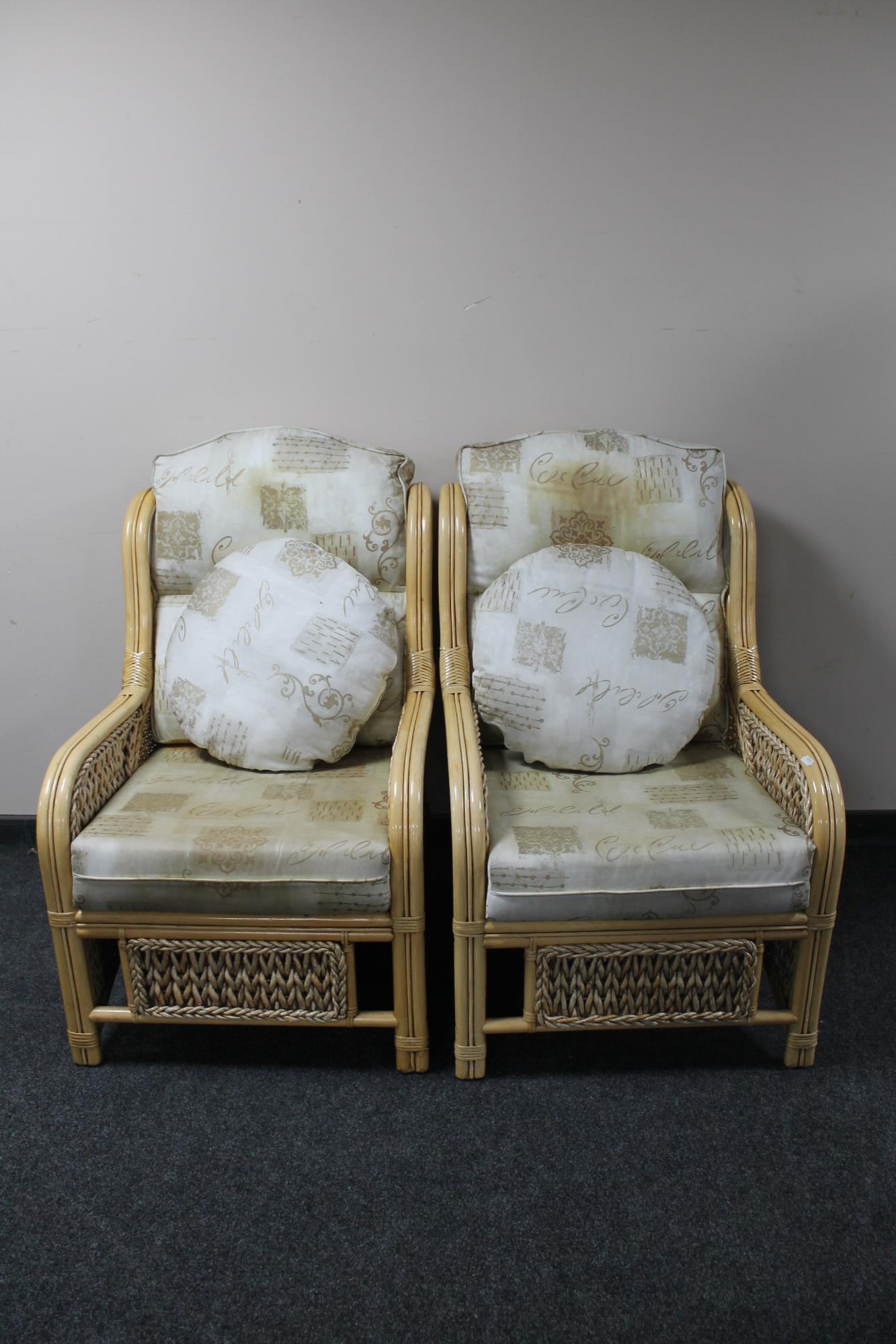 A pair of bamboo and wicker conservatory chairs with cushions