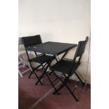 A folding rattan garden table and two chairs