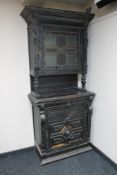 A late 19th century ebonised oak carved hunting cabinet with glazed leaded glass door