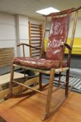 A mid century teak framed rocking chair with red burgandy leather covering