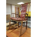 A mid century teak framed rocking chair with red burgandy leather covering