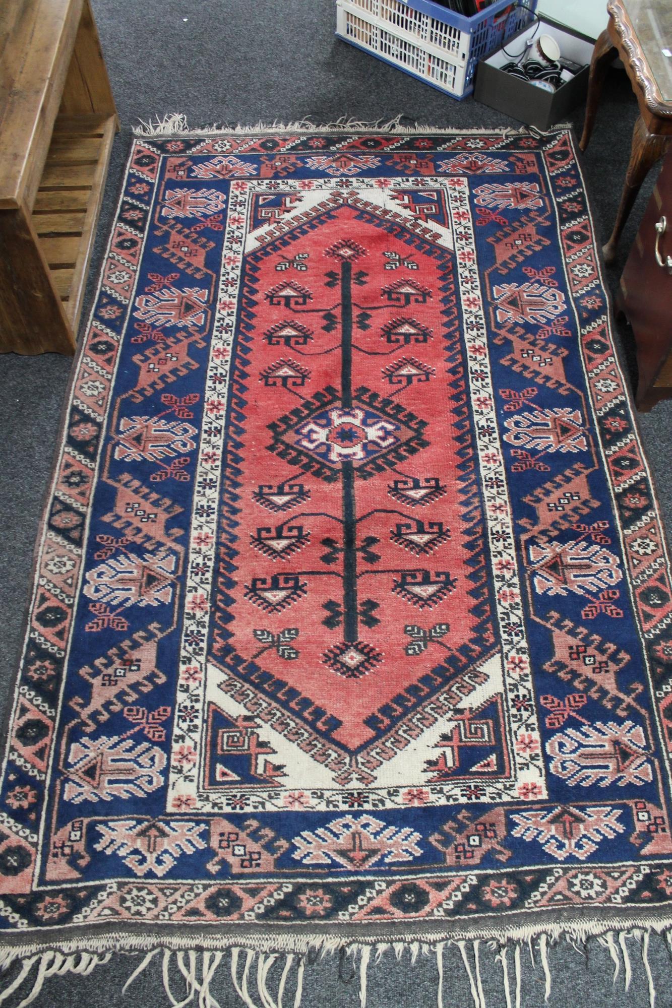 A Persian rug on salmon/blue ground,