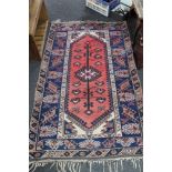 A Persian rug on salmon/blue ground,