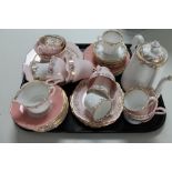 A tray of decorative pink lustre tea china
