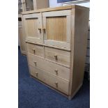 A light oak double door storage cabinet fitted with four drawers