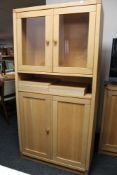 A light oak double door glazed cabinet