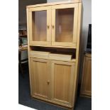 A light oak double door glazed cabinet
