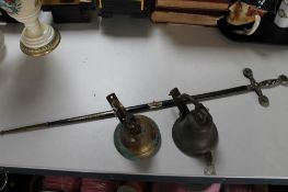 A pair of brass door bells together with a ceremonial style sword