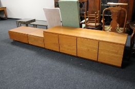 Three teak storage cabinets fitted with drawers and cupboard doors