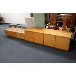 Three teak storage cabinets fitted with drawers and cupboard doors