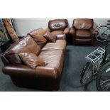 A brown leather three piece lounge suite and brown leather cushions