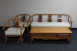 An Oriental style three piece lounge suite comprising four seater settee,