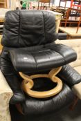 A black leather swivel chair with footstool